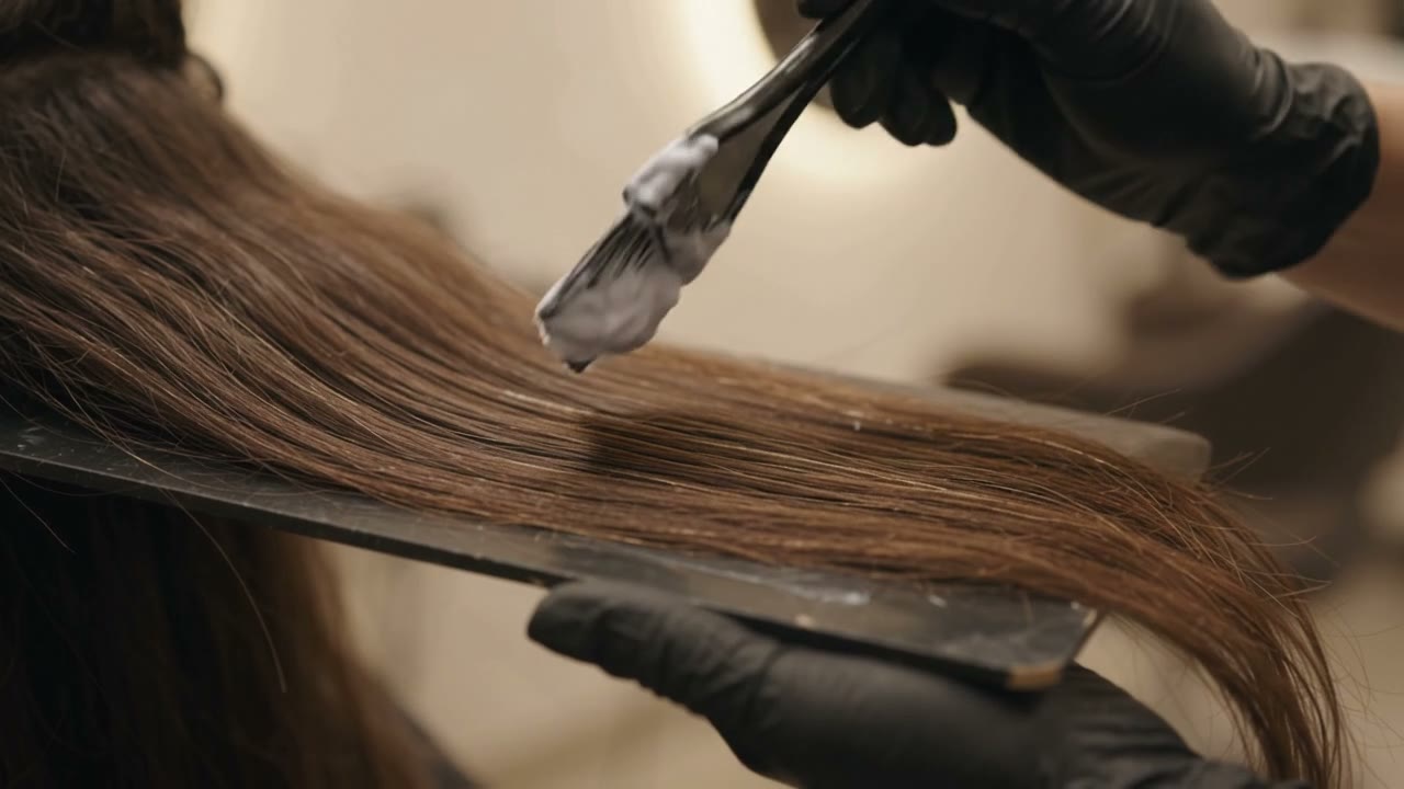 Balayage being hand-painted onto brown hair